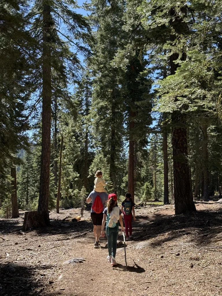 Luis carrying his youngest daughter on a hike